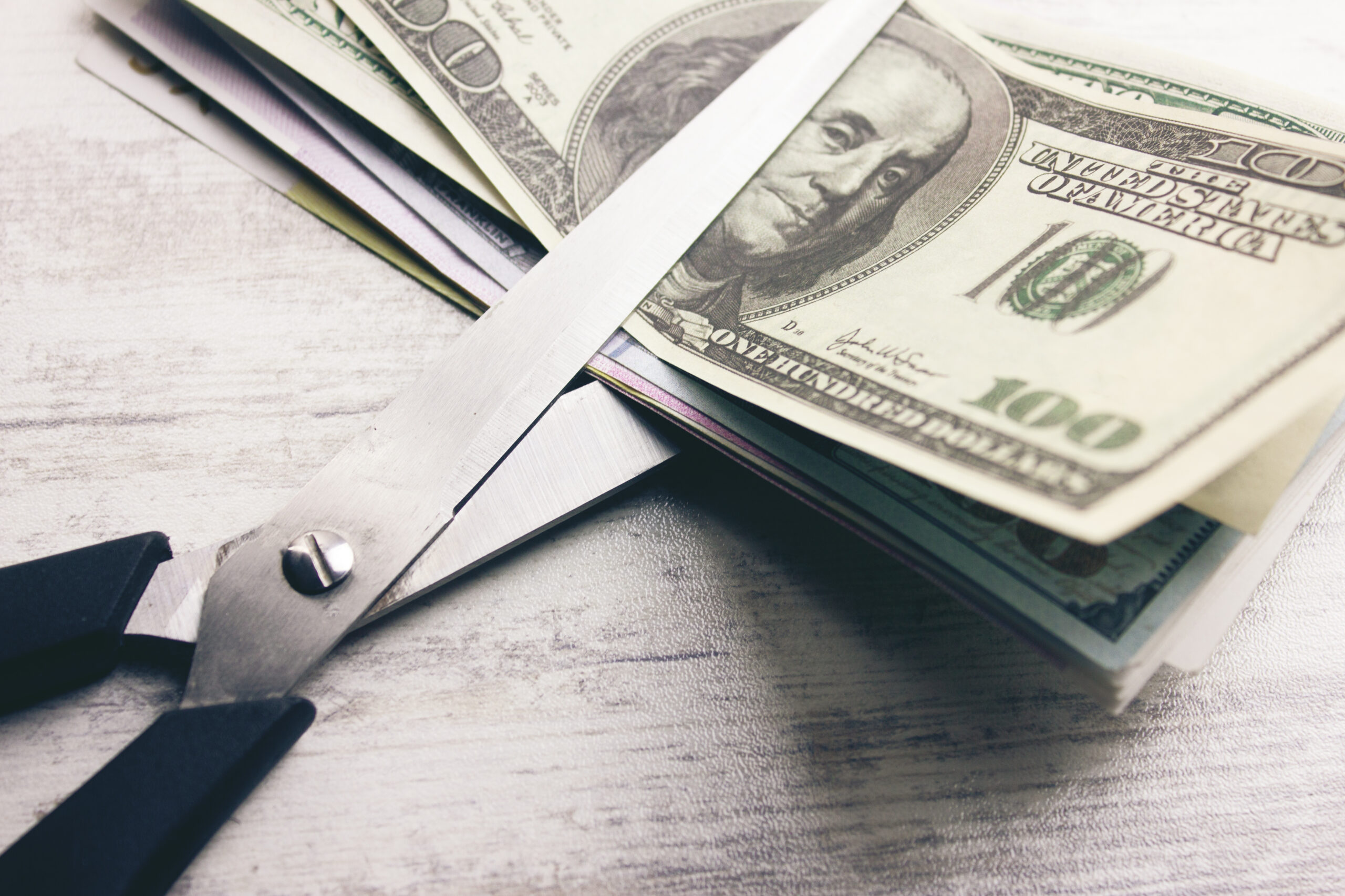 Dollar banknotes with scissors lying